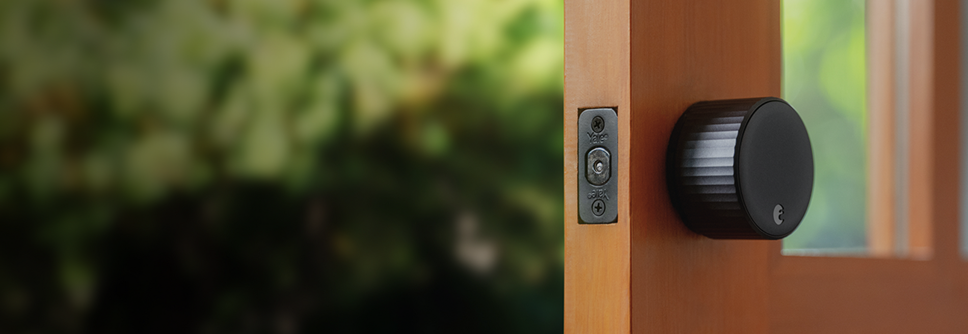 A black August wifi lock on an open door